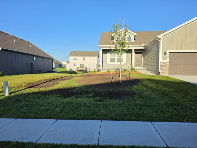 New sod and a freshly cut planting bed at a newly built home.